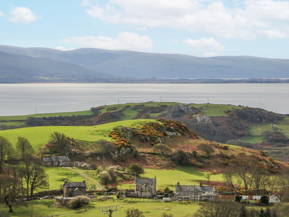 A view of cottages and green fields near a coastline at Little Barn near Criccieth