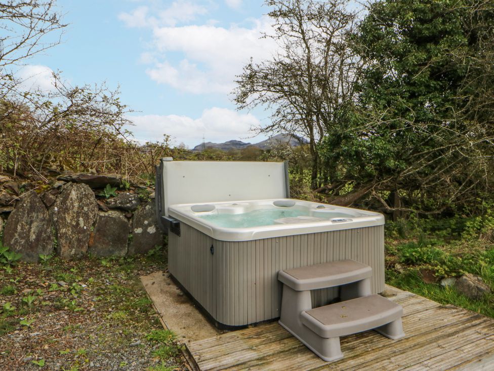 A hot tub with steps in an outdoor area at Little Barn near Criccieth