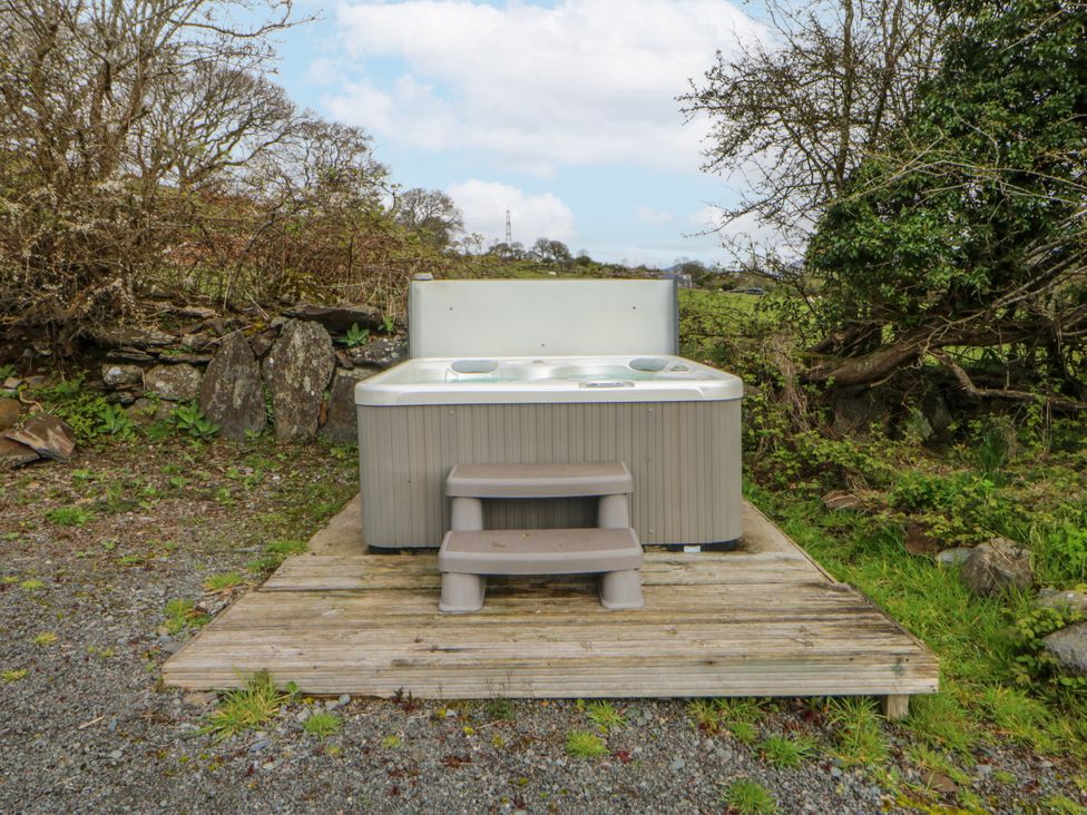 A hot tub with steps on a deck in the outdoor area at Little Barn near Criccieth