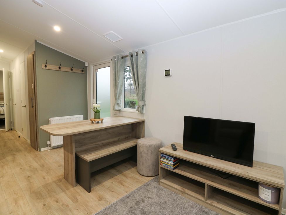 A dining area with a table and tv stand at 63 St Andrews in Prestonpans