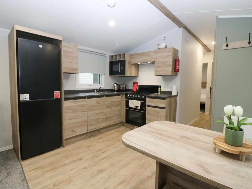 A kitchen with refrigerator and stove at 63 St Andrews in Prestonpans