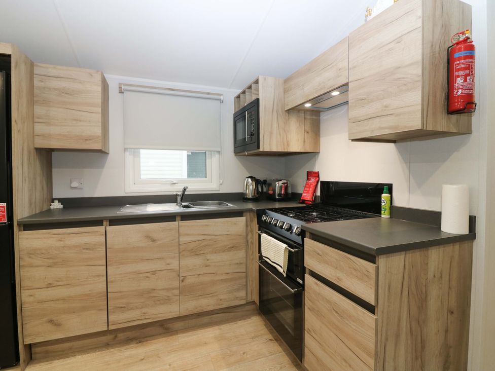 A kitchen with cabinets and appliances at 63 St Andrews in Prestonpans