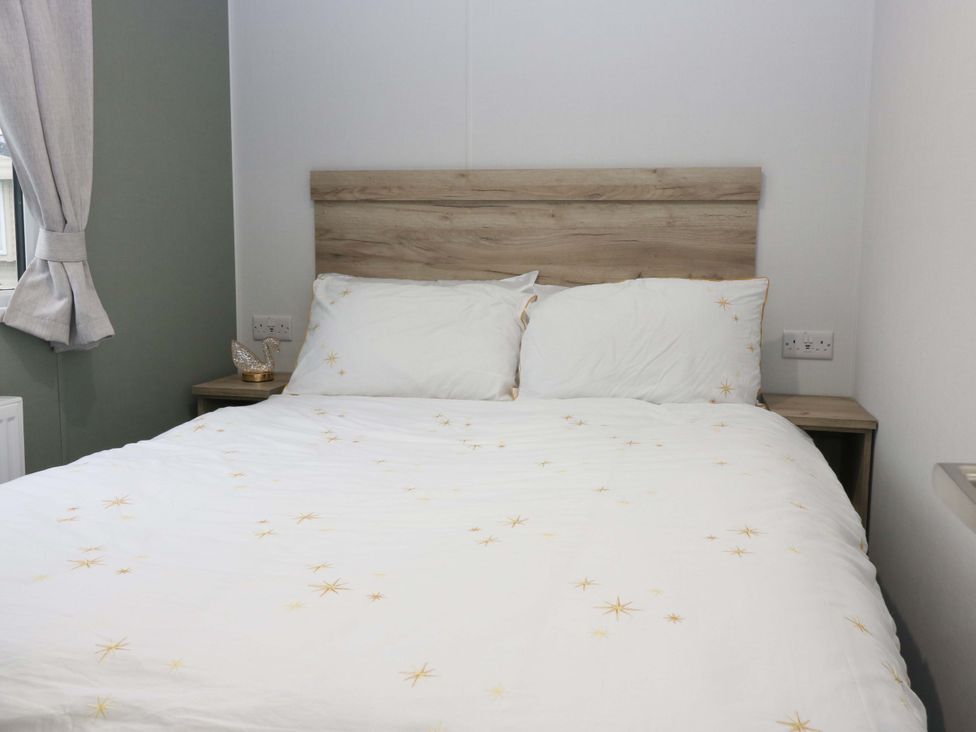 A bedroom with a bed and curtains at 63 St Andrews in Prestonpans