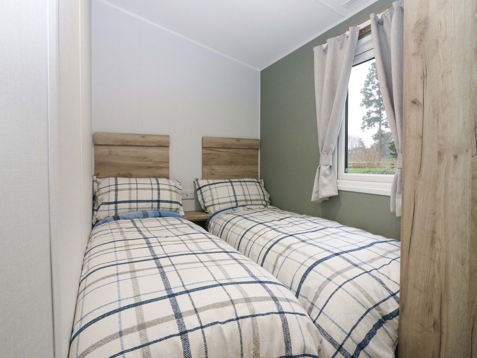 A bedroom with two beds and a window at 63 St Andrews in Prestonpans