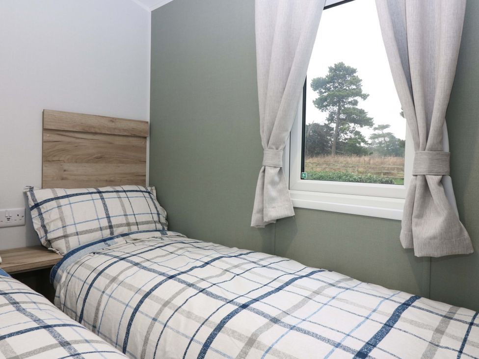 A bedroom with two beds and a window at 63 St Andrews in Prestonpans
