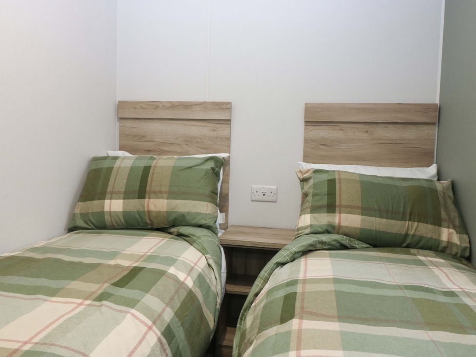 A bedroom with two single beds and a bedside table at 63 St Andrews in Prestonpans