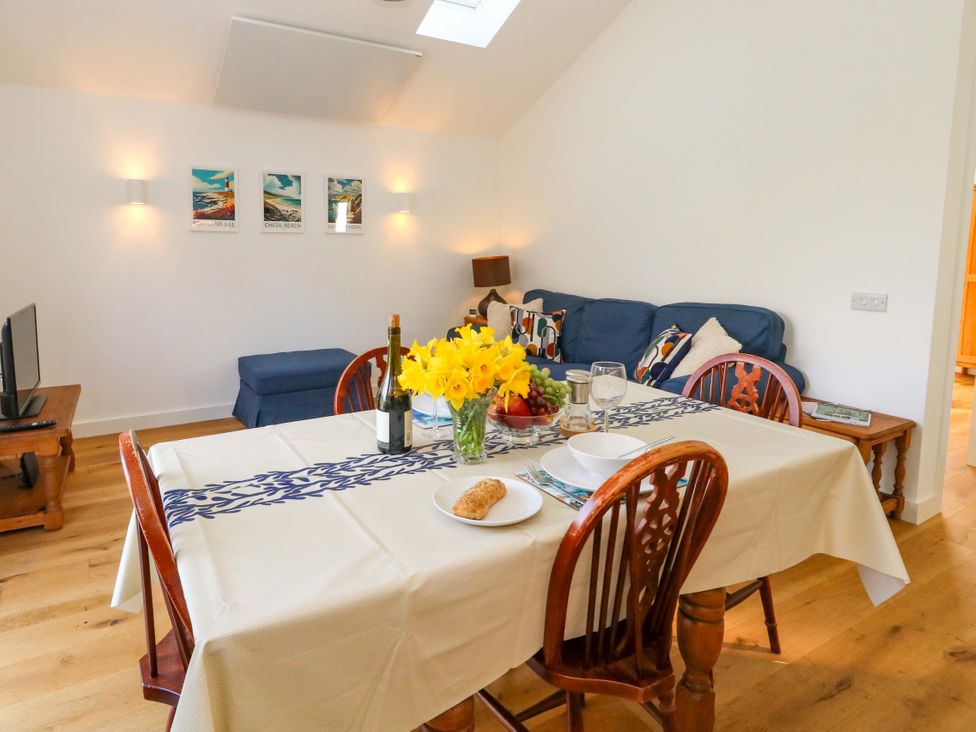 A dining room with a table and chairs at The Pebble in Dorchester