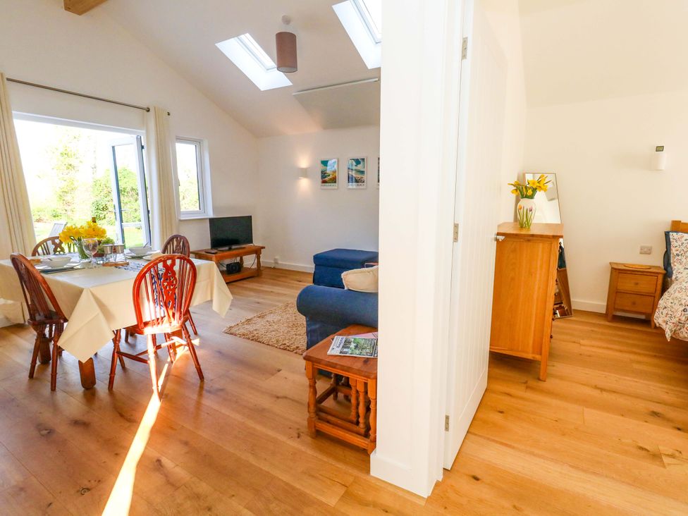 A living room with a dining area and furniture at The Pebble in Dorchester