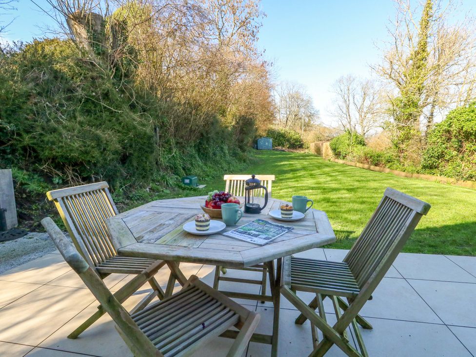 A patio with wooden furniture and a fruit bowl at The Pebble in Dorchester