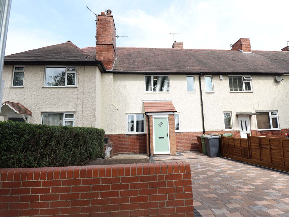 An exterior view of a house with a green door and brick wall at 271 Wragby Road in Lincoln