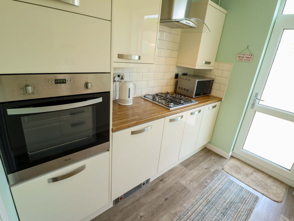 A kitchen with oven, gas hob, microwave and kettle at 271 Wragby Road in Lincoln