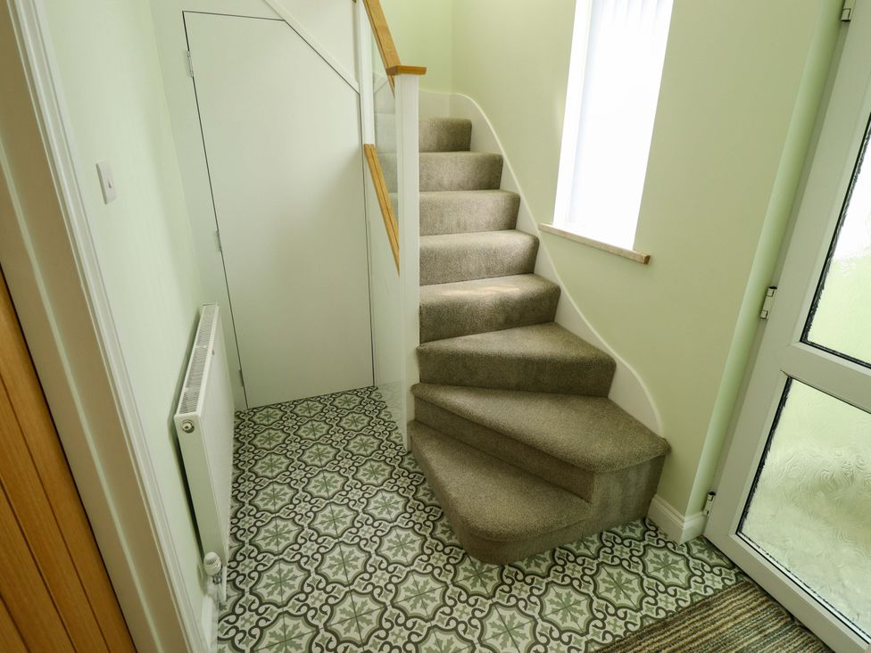 A hallway with a staircase and radiator at 271 Wragby Road in Lincoln