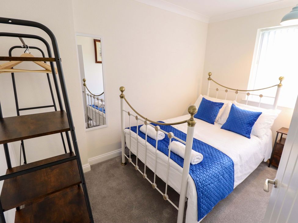 A bedroom with a bed and mirror at 271 Wragby Road, Lincoln