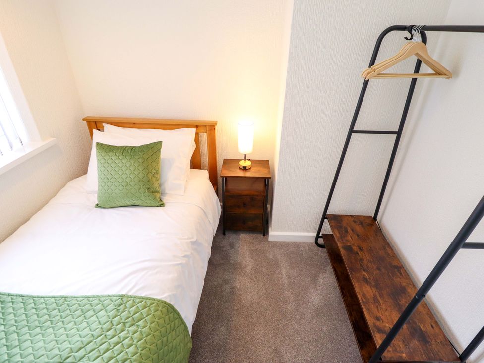 A bedroom with a bed and bedside lamp at 271 Wragby Road, Lincoln