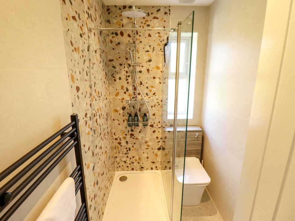 A bathroom with a shower, toilet, and sink at 271 Wragby Road in Lincoln