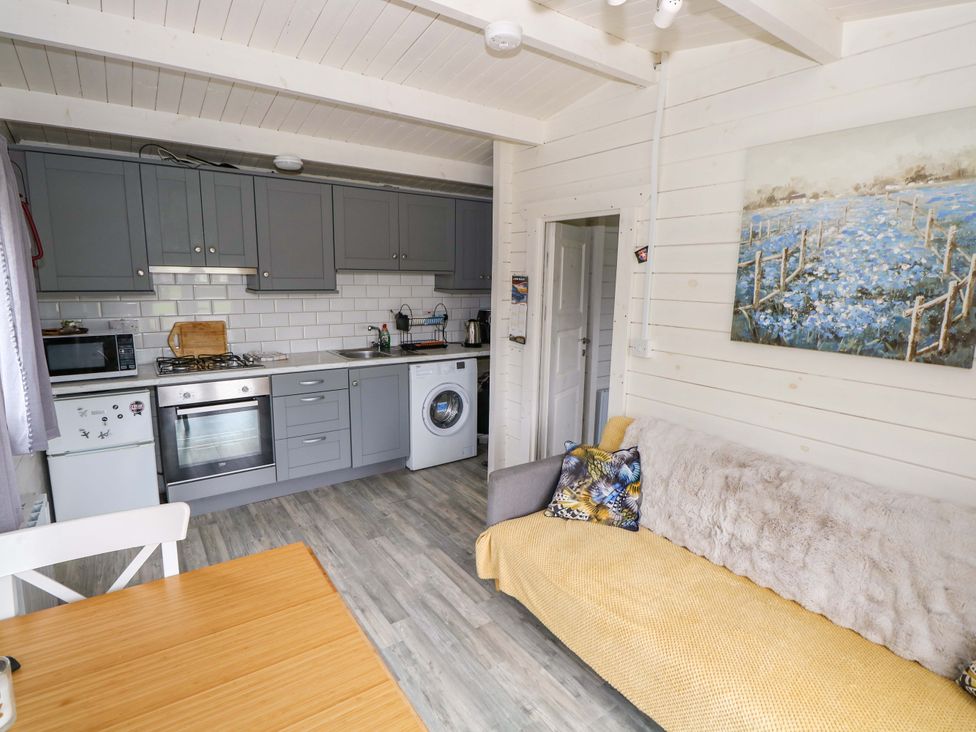 A kitchen with a sofa and dining table at Nellies Log Cabin in Kilcogy