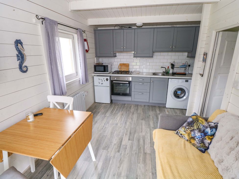 A kitchen with a table and chairs at Nellies Log Cabin in Kilcogy