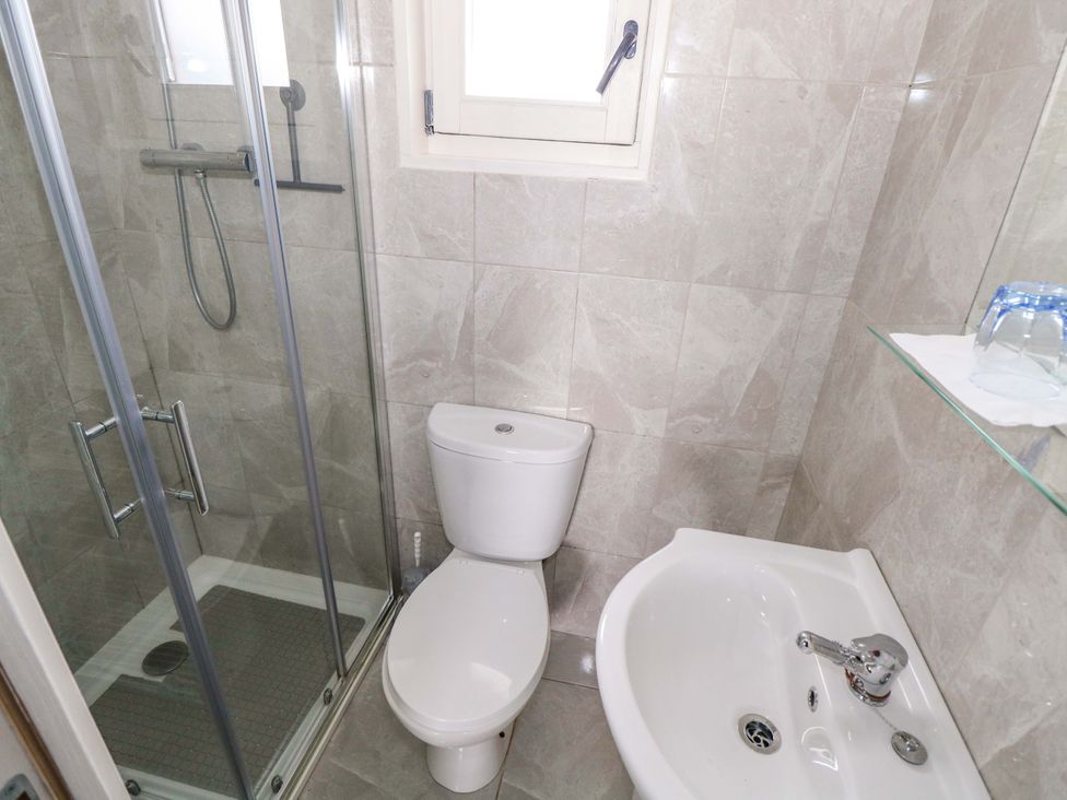 A bathroom with a shower, toilet, bidet, and sink at Nellies Log Cabin in Kilcogy