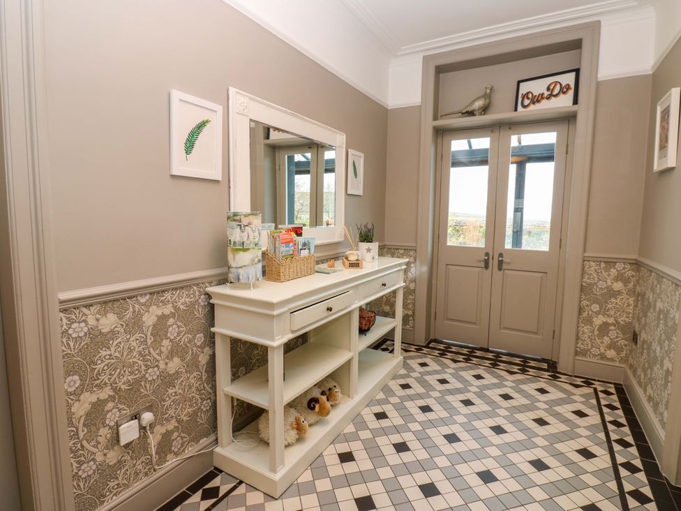 A hallway with a console table and mirror at Langcliffe House Kettlewell