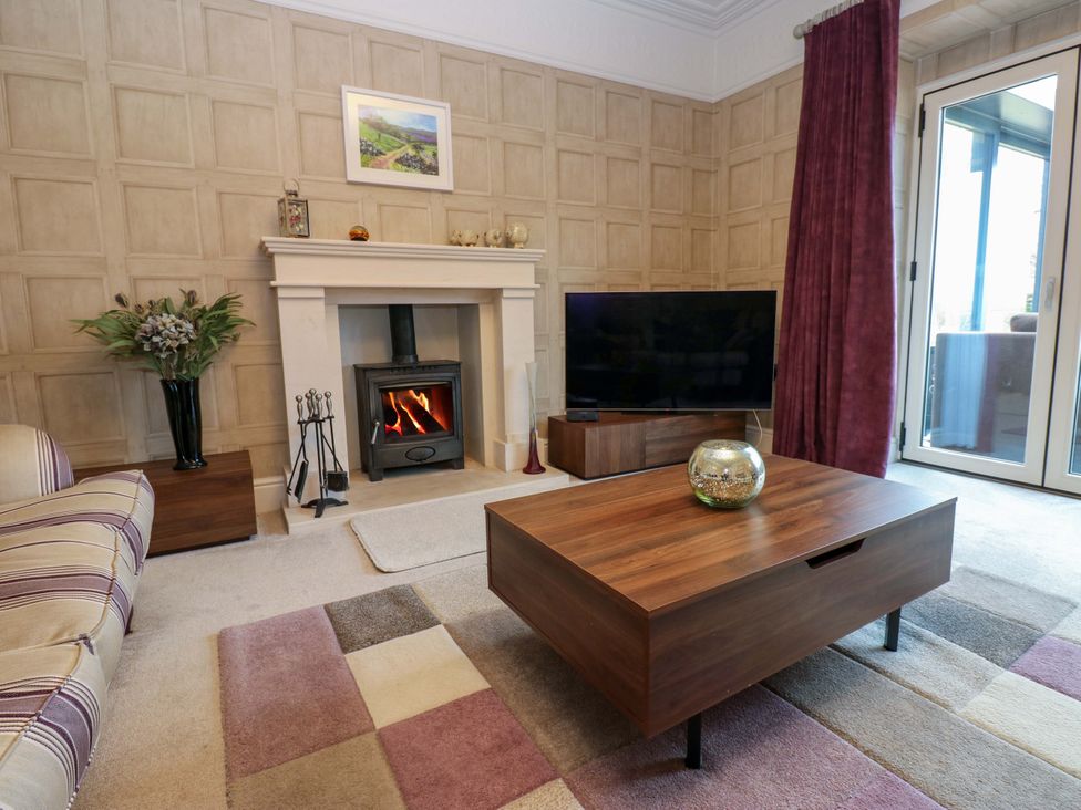 A living room with a coffee table and television at Langcliffe House in Kettlewell