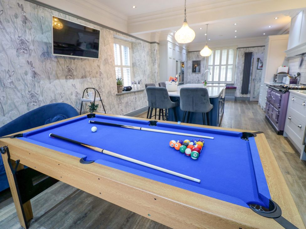 A game room with a pool table and bar stools at Langcliffe House in Kettlewell