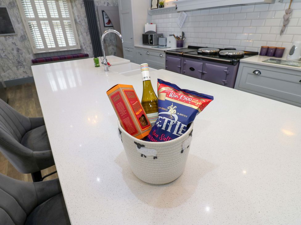 A kitchen counter with a bowl containing wine and snacks at Langcliffe House Kettlewell