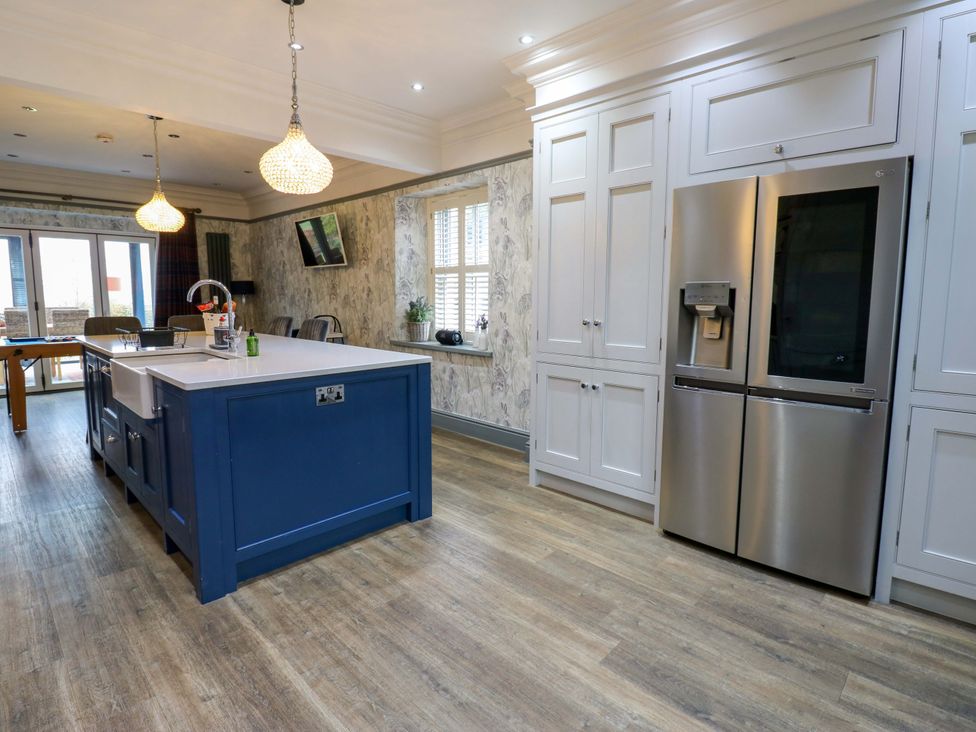 A kitchen with a refrigerator and kitchen island at Langcliffe House Kettlewell