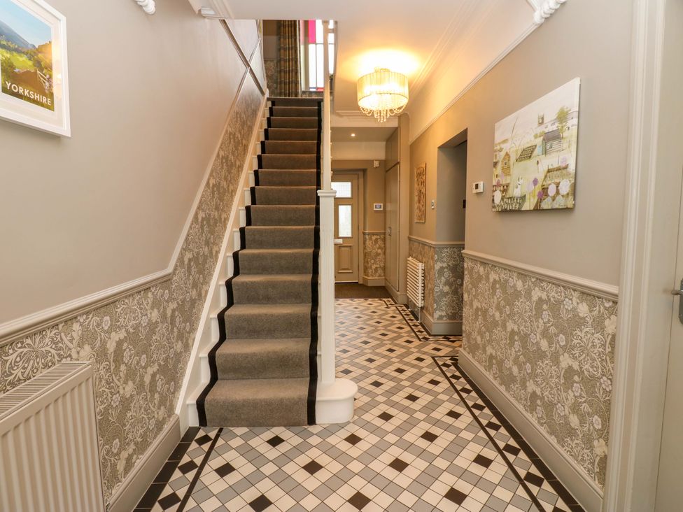 A hallway with a staircase and decorative features at Langcliffe House in Kettlewell