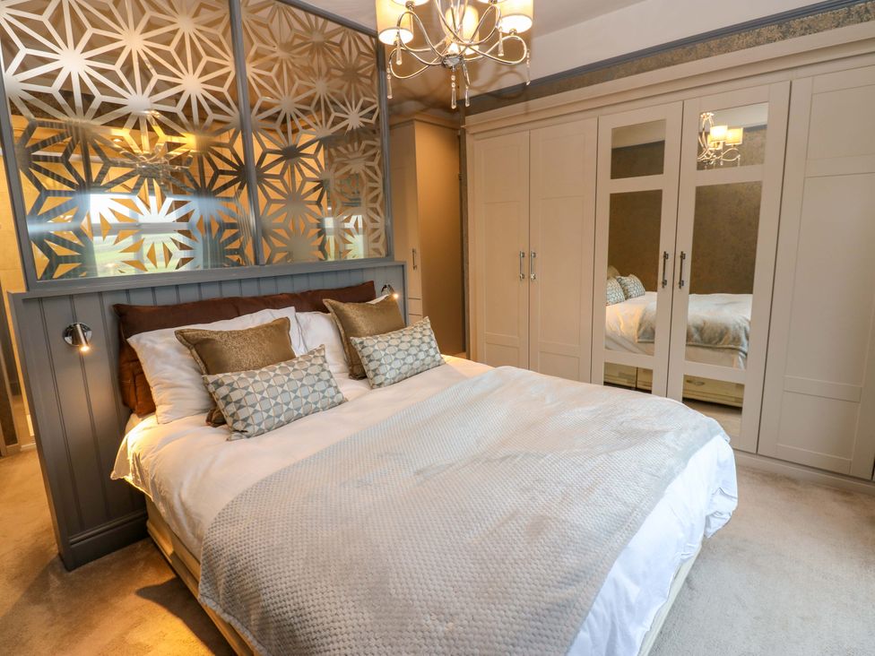 A bedroom with a bed and wardrobe at Langcliffe House in Kettlewell