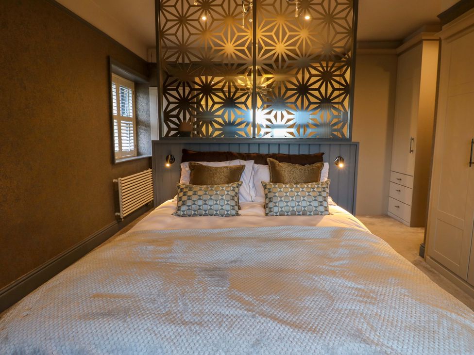 A bedroom with a bed and decorative pillows at Langcliffe House Kettlewell