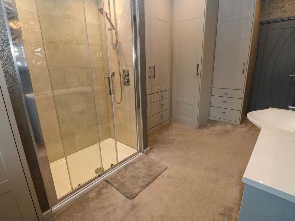 A bathroom with a shower and storage cabinets at Langcliffe House in Kettlewell