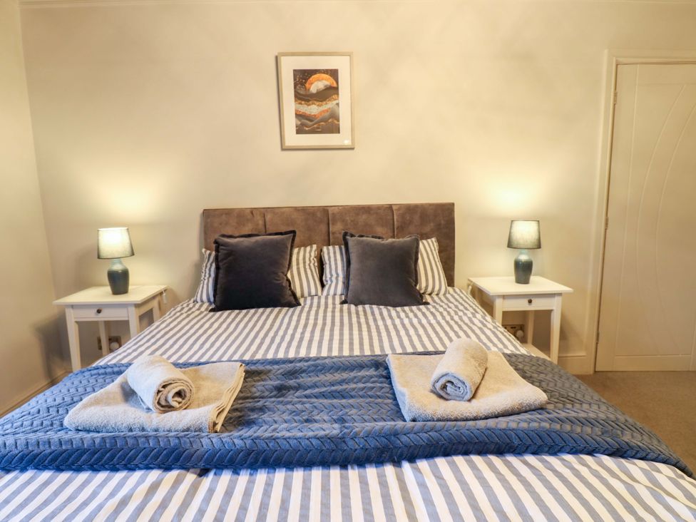 A bedroom with a large bed and bedside tables at Langcliffe House in Kettlewell