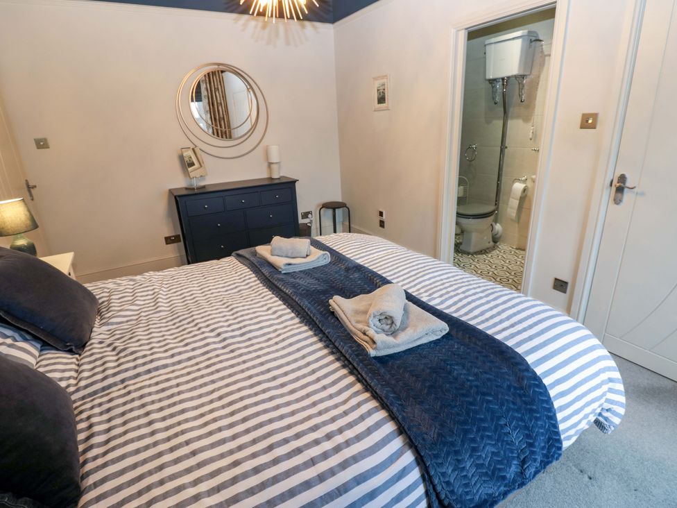 A bedroom with a bed and a mirror at Langcliffe House in Kettlewell