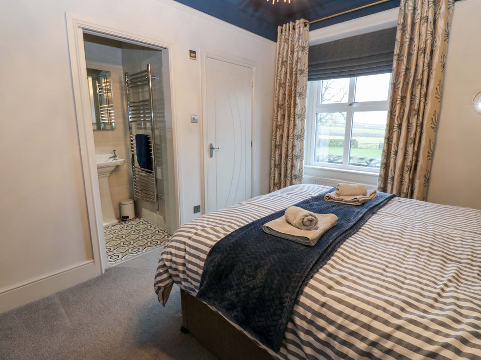 A bedroom with a bed and adjoining bathroom at Langcliffe House Kettlewell