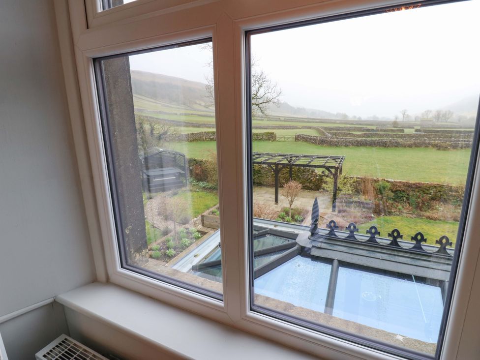 A view of the garden through a window at Langcliffe House in Kettlewell