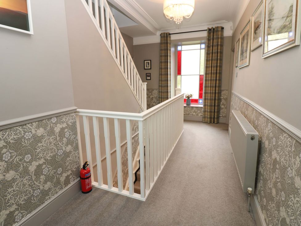A hallway with a staircase and window at Langcliffe House Kettlewell