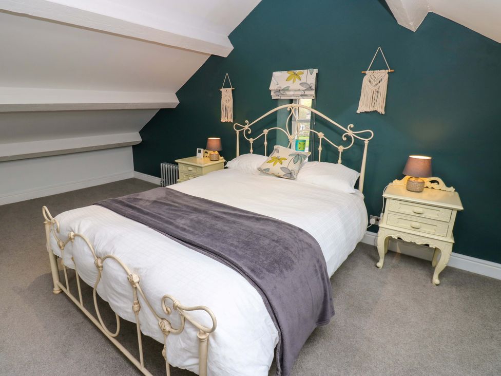 A bedroom with a bed and nightstand at Langcliffe House in Kettlewell