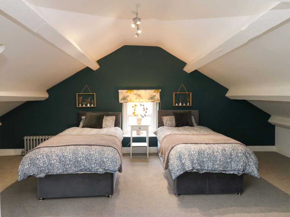 A bedroom with two beds and a window at Langcliffe House in Kettlewell