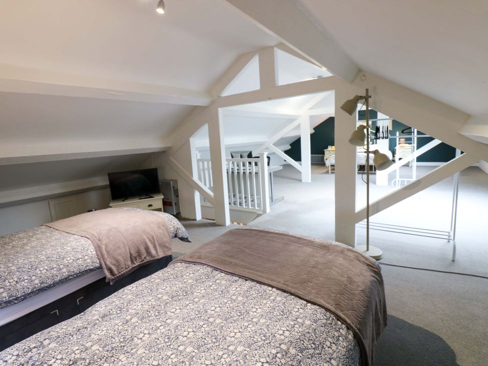 A bedroom with two beds and a television at Langcliffe House Kettlewell
