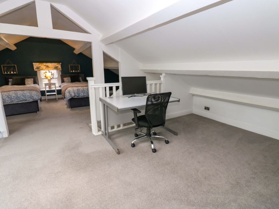 A bedroom with two beds and a desk at Langcliffe House Kettlewell