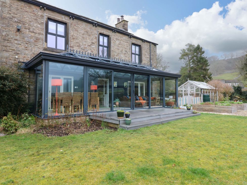 A house with a garden and a glass extension at Langcliffe House in Kettlewell