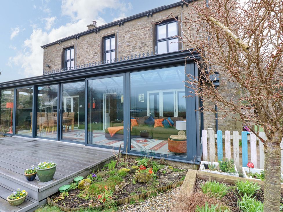 A house with large windows and a deck in the garden at Langcliffe House Kettlewell
