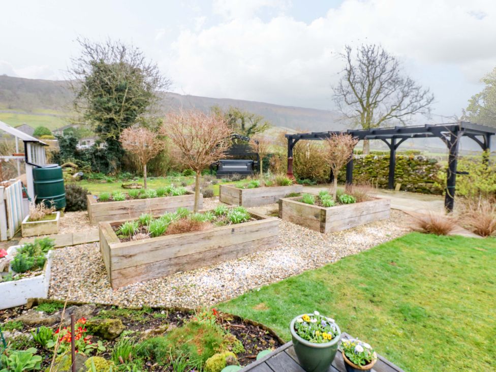 A garden with raised planters and gravel paths at Langcliffe House in Kettlewell