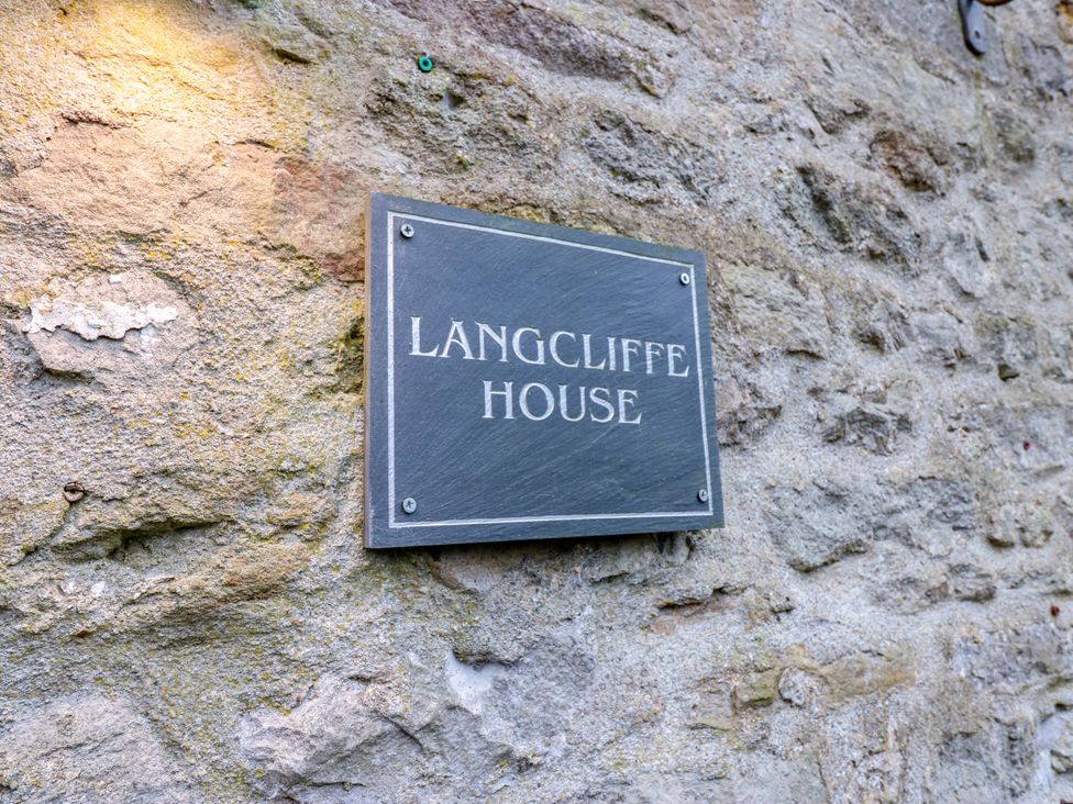 A plaque on a stone wall at Langcliffe House in Kettlewell