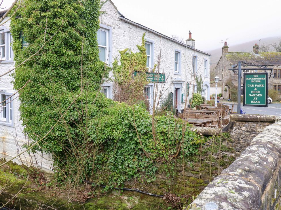 An outdoor view of The Bachelors Hotel with car park and beer garden at Kettlewell