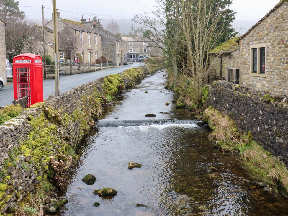A telephone box near a river and stone wall at Langcliffe House in Kettlewell