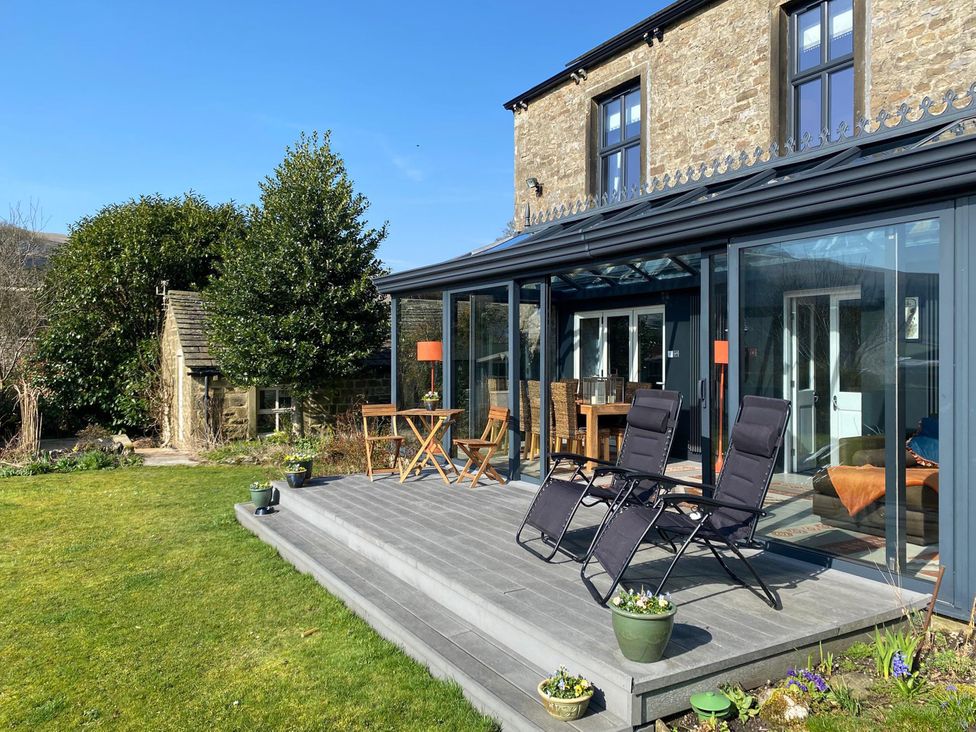 A garden with chairs and a table at Langcliffe House in Kettlewell