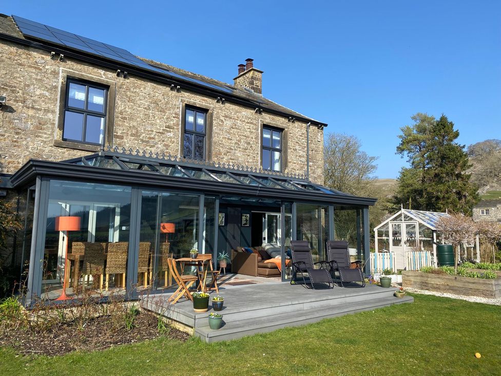 A house with a conservatory and decking at Langcliffe House Kettlewell