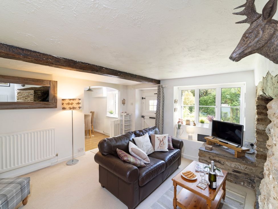 A living room with a sofa, coffee table, and television at Lavender Cottage in Bourton, Dorset