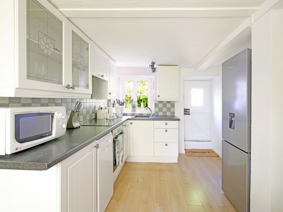 A kitchen with a microwave and refrigerator at Lavender Cottage in Bourton, Dorset